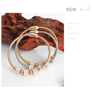 Detailed close-up of luxury gold and silver snake chain bracelets with sparkling crystals