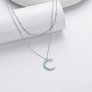 Detail of S925 sterling silver layered necklace with crescent moon and blue stones
