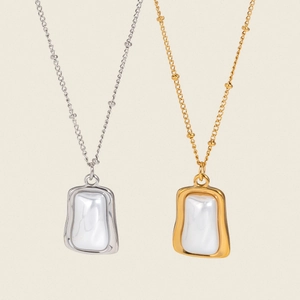 Colliers en perles carrées dorées et argentées sur fond beige minimaliste