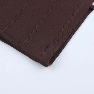 Détail de tissu en maille côtelée marron foncé montrant coutures et texture