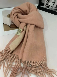 Detail of soft pink and beige cashmere-feel scarf showing fringes and high-quality texture