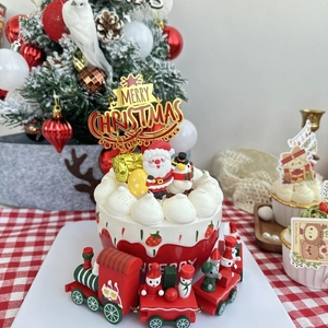 Macro detail of Merry Christmas cake toppers and miniature festive wooden train set