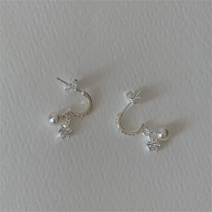 Detail of S925 silver C-shape earrings with hanging white pearl and star-shaped zircon