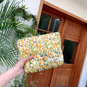 Close-up of canvas tulip cosmetic bag with Sozakka brand label and floral print