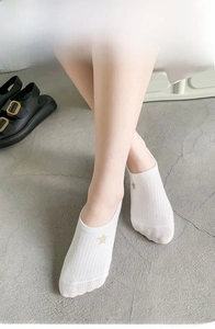 Detail of white cotton no-show socks with golden star embroidery on ribbed fabric