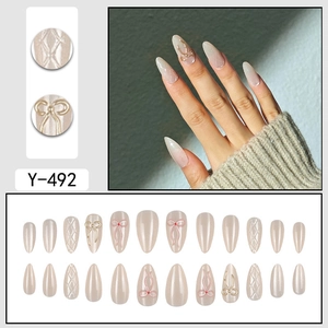 Almond-shaped press-on nails set with 3D bows, quilted texture, and aurora nude finish