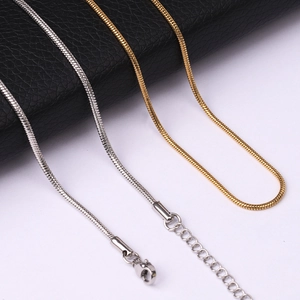 Detailed macro view of gold and silver snake bone necklaces with lobster clasps
