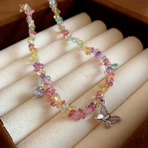 Detail of colorful stone beads necklace with silver butterfly and heart zircon charms