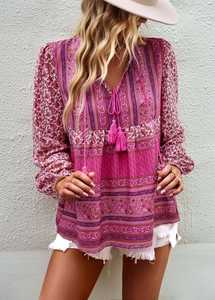 Detail of pink and purple floral bohemian blouse with V-neckline and tassel ties