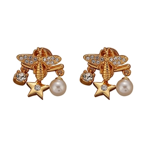 Luxurious gold bee earrings with crystal stars and pearl drops on a white background