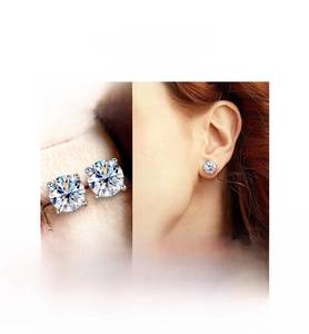 Detailed view of four-prong round moissanite stud earrings in polished silver finish