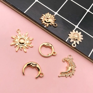 Macro detail of gold celestial alloy charms featuring sun and moon for DIY jewelry making