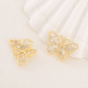 Detailed macro shot of gold butterfly charms with sparkling zircon stones for jewelry making