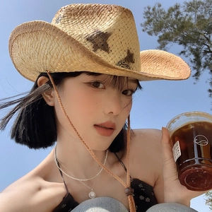 Detail of wide brim straw cowboy hat with star patterns and adjustable wind strap