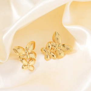 Elegant gold butterfly dangle earrings for women on a premium white satin fabric background