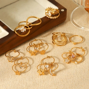 Elegant gold titanium steel ring set with zircon butterfly and heart charms on wood display