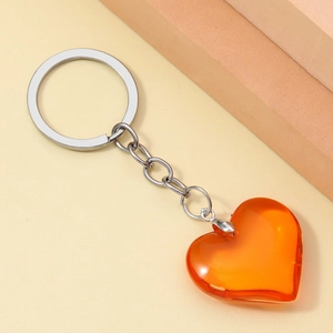 Detailed close-up of a translucent orange 3D resin heart keychain on a silver chain