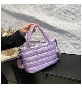 Detail of purple quilted down tote bag with metallic finish and adjustable strap