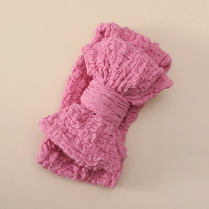 Close-up of pink oversized double-layered bow headband in textured crinkle fabric