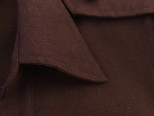Macro del bavero di un abito in lino marrone con cuciture dettagliate e trama
