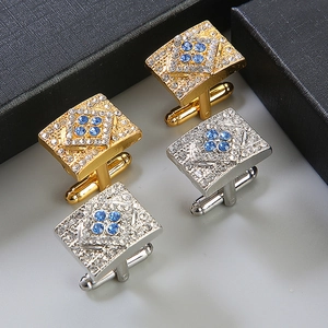 Macro shot of silver and gold rectangular cufflinks with blue and clear crystals