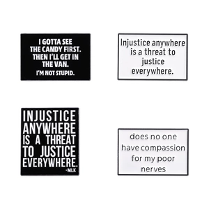 Set of four black and white geometric enamel lapel pins with motivational quotes