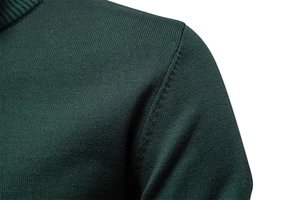 Gros plan sur la maille de coton vert foncé et couture d'épaule du pull pour homme