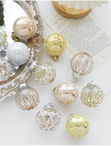 Close-up of 6cm decorative Christmas balls with gold stars and wire mesh on white desk