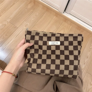 Textura detallada del bolso de pana a cuadros marrones con etiqueta de tela blanca