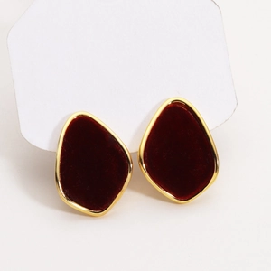 Close-up of irregular 18K gold plated earrings with burgundy flocking and matte texture