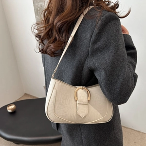 Retro cream white leather shoulder bag with gold D-ring buckle shown on a female model