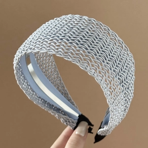 Detail of light blue braided headband showing intricate woven texture and non-slip strip