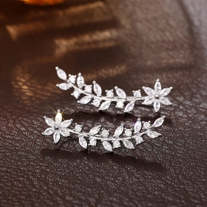 Macro detail of silver leaf crawler earrings with marquise and round clear rhinestones