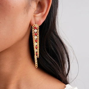 Detail view of 18k gold-plated tassel earrings with red and white zircon gemstones