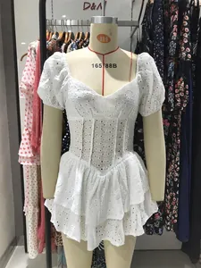 Detalle de vestido de encaje de algodón blanco con mangas abullonadas y volantes