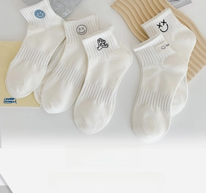 Detail of white cotton socks with cute cartoon embroidery and ribbed cuffs