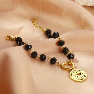 Retro black crystal beaded bracelet with gold MAMA pendant on elegant silk background