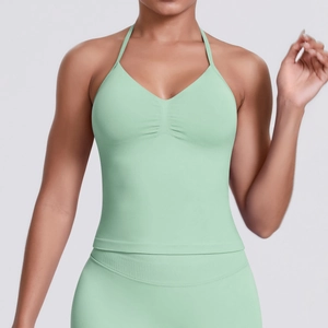 Detail of mint green seamless ribbed yoga top with halter neck and ruched chest design
