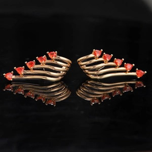 Symmetric detail of golden angel wing earrings with orange triangular crystals and reflections