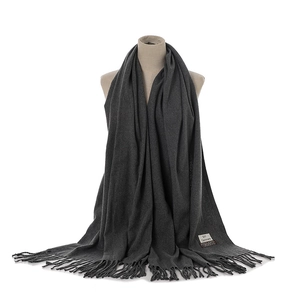 Detailed view of the dark grey cashmere-feel fringe scarf, showing soft texture and label.