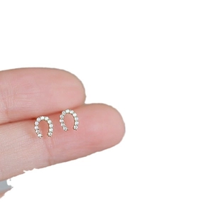 Orecchini a ferro di cavallo in argento S925 con zirconi, mostrati tra le dita per le misure