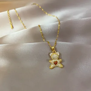 Detail of gold teddy bear pendant with micro-pave zircons and red heart stone