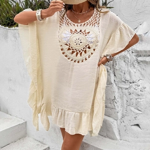Close-up of beige crochet beach cover-up featuring mandala knit patterns and ruffled hems