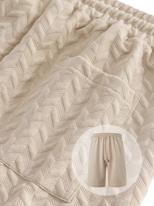 Detailed macro view of the jacquard texture and stitching on beige casual shorts