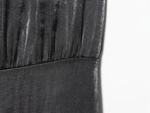 Détail de la combinaison à paillettes gris foncé montrant le tissu et les plis