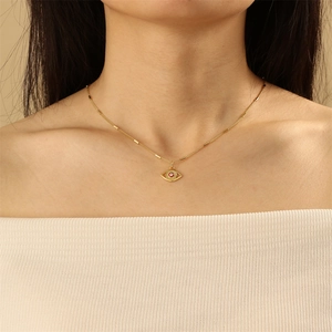 Close-up of gold evil eye necklace with red enamel pendant and cylindrical chain
