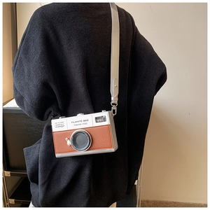 Detailed back view of model wearing a vintage camera-shaped crossbody bag with wide strap