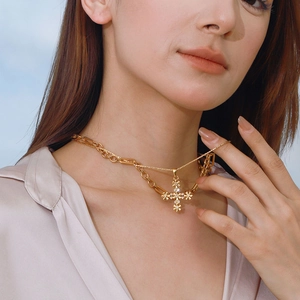 Collana con ciondolo a croce dorata di lusso con maglie miste e zirconi indossata da modella