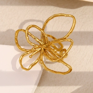 Artistic close-up of a 18K gold-plated stainless steel flower ring on geometric stand