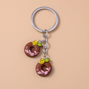 Detailed view of chocolate donut charms with yellow roses on a metal keychain ring